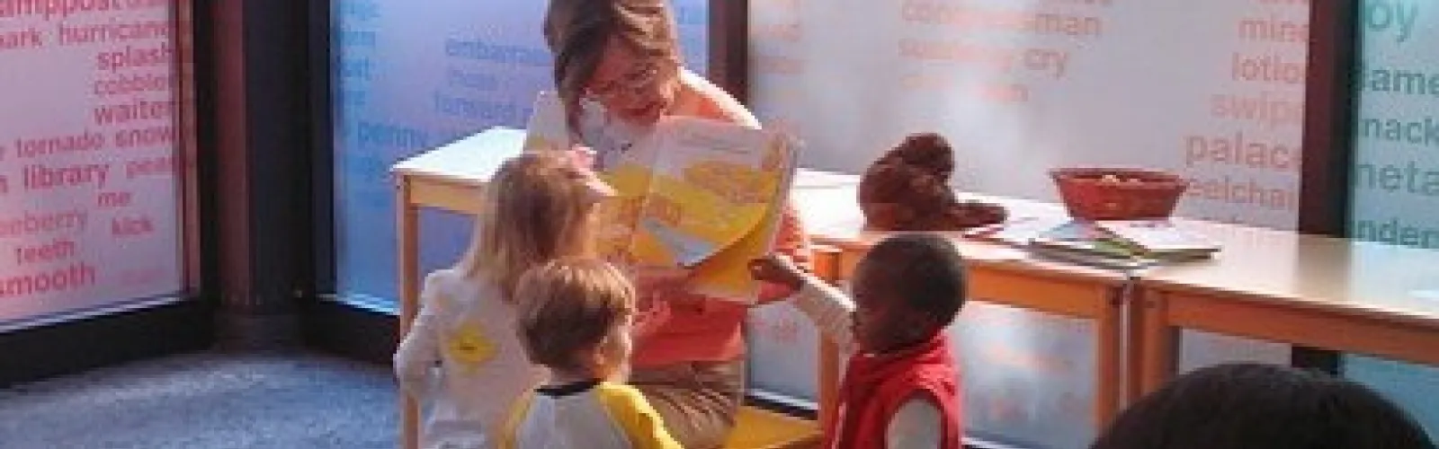 Storytime presenter and children reading a book together